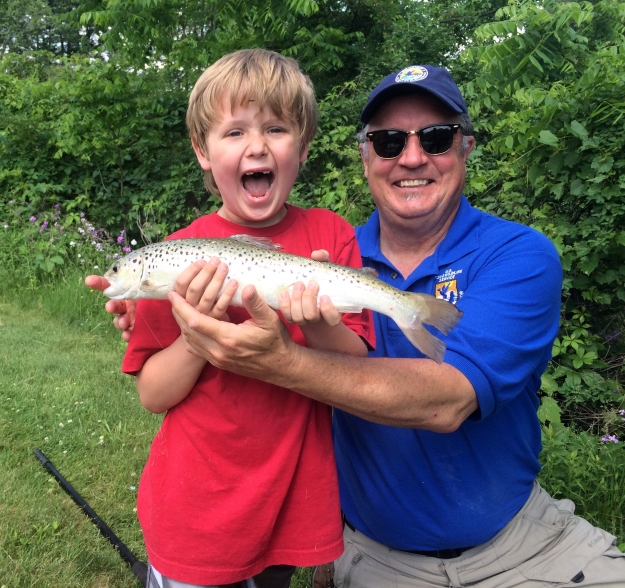 An excited young angler shows off his prize catch with Dr. Mike Millard at the Northeast Fishery Center Kid's Fishing Day. Photo credit:USFWS