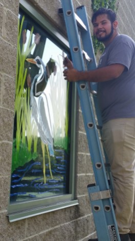 Patuxent intern Abraham Lopez painting staff window